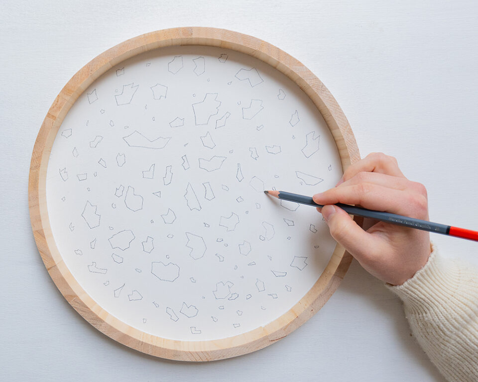 Ein Muster wird auf das Terrazzo-Tablett gemalt